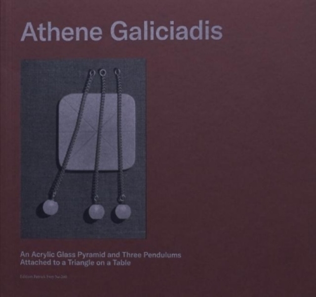 An Acrylic Glass Pyramid and Three Pendulums attached to a Triangle on a Table